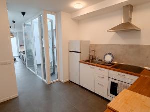 a kitchen with a white refrigerator and a sink at apartment in La Santa, Lanzarote, village by the Sea in La Santa