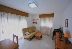 a living room with a couch and a table at Villamar Orange Costa in Benicàssim