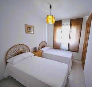 a hotel room with two beds and a chandelier at Villamar Orange Costa in Benicàssim