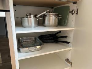 two pots and pans on a shelf in a kitchen at Maison de ville à Etampes in Étampes