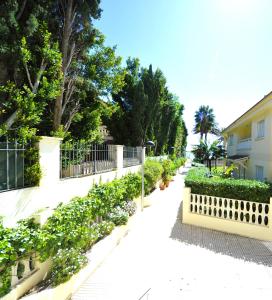 a sidewalk with a fence and some bushes and trees at Villamar Orange Costa in Benicàssim
