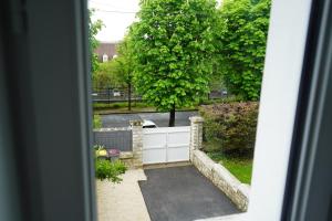 a view of a driveway with a fence and a tree at Maison de ville à Etampes in Étampes