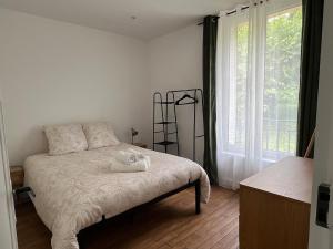 a bedroom with a bed and a large window at Maison de ville à Etampes in Étampes