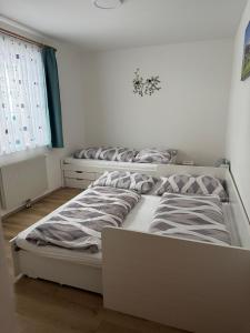 a white bedroom with two beds and a window at Ferienhaus am Bauernhof mit Terrasse nähe Wexl Arena in Sankt Corona am Wechsel