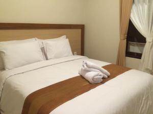a bedroom with a bed with a white towel on it at Buyan Homestay in Sanur