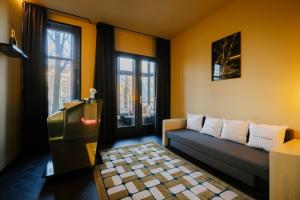 a living room with a couch and two windows at Supper Boutique Suites in Amsterdam