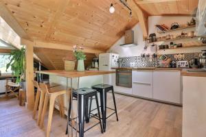 a kitchen with a table and stools in a room at L annexe in Saint-Jean-d'Aulps +5 photos