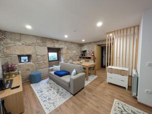 a living room with a couch and a stone wall at Casas do Pastor in Seia