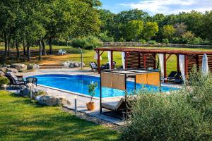 a swimming pool in a yard with a pavilion next to it at Stancija Negričani in Divšići