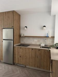 a kitchen with wooden cabinets and a refrigerator at Hurtado Siete in Jaén