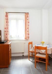 a kitchen with a table and a chair and a window at Ferienwohnung-Hoffmann-Harzgerode in Harzgerode