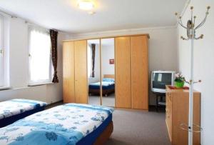 a bedroom with two beds and a tv in it at Ferienwohnung-Hoffmann-Harzgerode in Harzgerode