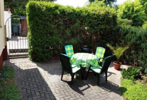 a table with four chairs and a green and yellow checkered table and chairs at Ferienwohnung-Hoffmann-Harzgerode in Harzgerode