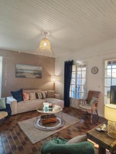 a living room with a couch and a table at Le Clos de Saint Georges in Saint-Georges-dʼOléron