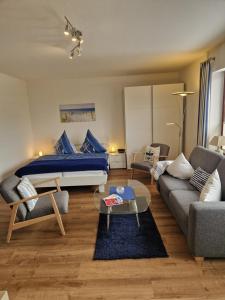 a bedroom with a bed and a living room at Appartementhaus Diana in Grömitz
