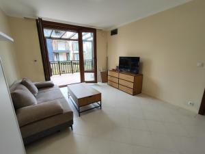 a living room with a couch and a tv at Santa Marina Breeze - One bedroom apartment in Sozopol