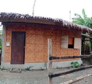a small brick building with a door and a window at Kalma Kubo Siargao in San Isidro