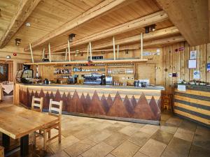 a restaurant with a bar with a table and chairs at Chalet Morel 1586 Hotel & Spa in Limone Piemonte