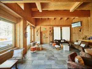 a living room with couches and tables in a room at Chalet Morel 1586 Hotel & Spa in Limone Piemonte