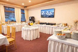a banquet room with tables with white tablecloths and plates at Hotel Batzenhäusl in Innsbruck +153 photos