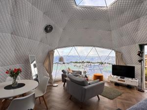 a living room with a large room with a large window at Sunset Ridge - Luxury Geodesic Dome set in the beautiful countryside in Porkellis