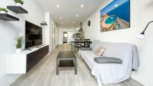 a living room with a white couch and a table at Guanarteme Vista Surf, Las Canteras in Las Palmas de Gran Canaria