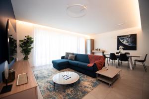 a living room with a blue couch and a table at Maison Selva - Corte Brunati Villetta Deluxe con piscina e garage in Salò
