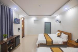 a bedroom with a bed and a desk in it at Khách sạn Ngọc Anh in Long Hai