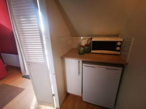 a small kitchen with a microwave on a counter at Le studio in Pontchâteau