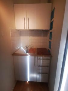 a small kitchen with white cabinets and a sink at Le studio in Pontchâteau