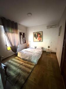 a bedroom with a large bed and a wooden floor at Appartement plein centre marrakech p in Marrakesh