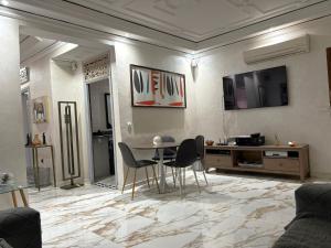 a living room with a table and chairs at Appartement plein centre marrakech p in Marrakesh