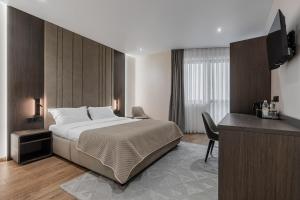 a hotel room with a bed and a desk at Villa Elena SPA & Resort in Bukovel