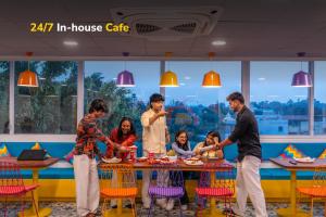 a group of people standing around a table in a restaurant at goSTOPS Bengaluru, Indiranagar - Private Rooms & Dorms in Bangalore