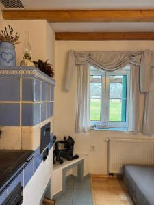 a living room with a fireplace and a window at Chalupa POHÁDKA Moravský kras in Vavřinec +6 photos
