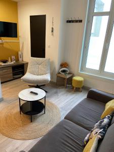 a living room with a couch and a table at "Appartement sur digue" proche de la plage avec wifi in Wimereux