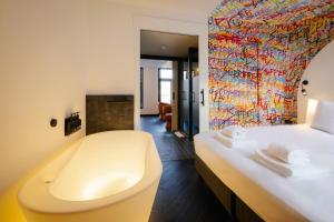 a bathroom with a bath tub and a bed at Supper Boutique Suites in Amsterdam +46 photos