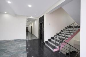a staircase in a house with a pink railing at FabHotel Golden Suites Near Puri Beach in Puri