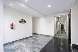 a hallway with white walls and a fire hydrant on the wall at FabHotel Golden Suites Near Puri Beach in Puri