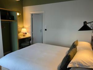 a bedroom with a bed and a desk and a desk at Monsieur Jules Hôtel Clamart in Clamart