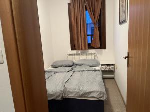 a small bed in a room with a window at Grand Panorama Apartment in Fojnica
