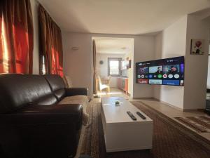 a living room with a couch and a flat screen tv at Grand Panorama Apartment in Fojnica