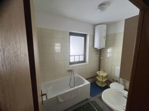 a bathroom with a tub and a toilet and a sink at Grand Panorama Apartment in Fojnica +14 photos