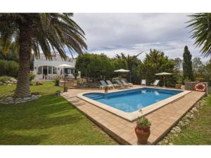 a swimming pool in a yard next to a house at Alaior Villa with Private Pool in Alaior