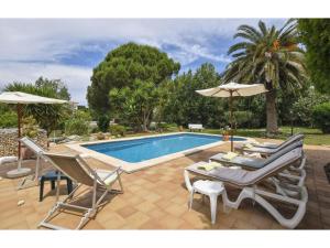 a swimming pool with chairs and umbrellas next to a pool at Alaior Villa with Private Pool in Alaior
