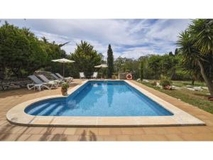 a swimming pool in a yard with chairs and umbrellas at Alaior Villa with Private Pool in Alaior