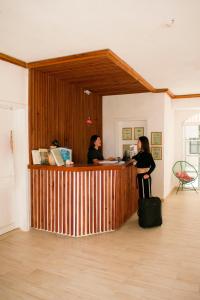 two women standing at a counter in a room at Balu Hotel in Isla Mujeres