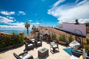 a patio with chairs and a view of the ocean at Cà de Matagè by Le Case di Tati in Riva Ligure