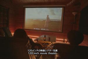 a large screen with a man standing on a movie at Riverside Oasis WAKUWAKU-BASE in Yabuhara