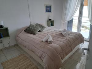 a bedroom with a large bed with towels on it at Lagonisi Cottage - with spacious garden in Áyios Nikólaos +16 photos